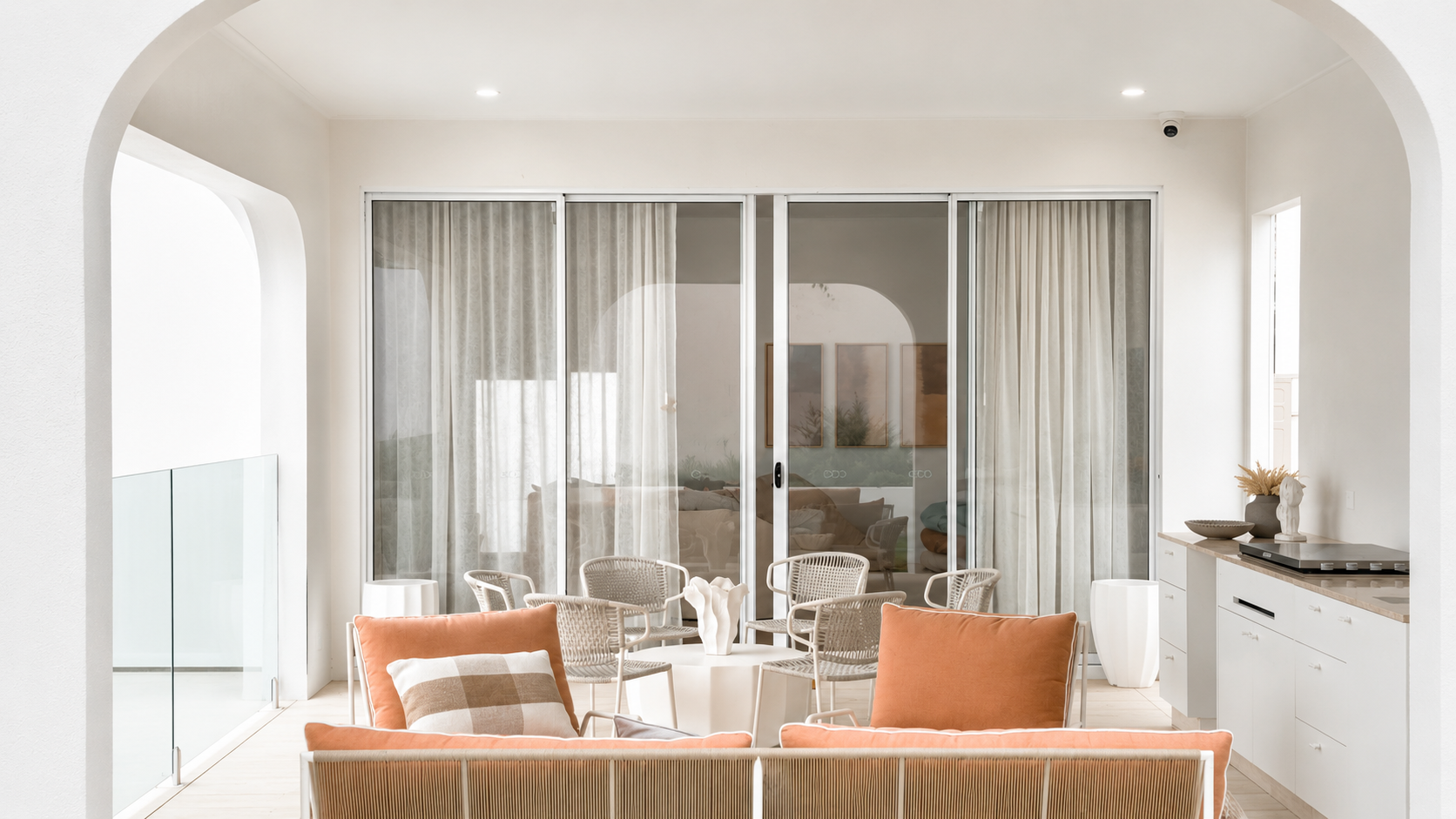 Custom sheer curtains installed across large sliding doors in a modern Brisbane outdoor entertaining area by Security Screens Qld.